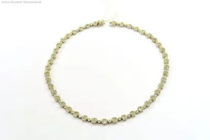 A une rangée de maillons formant des petites fleurs serties de diamants taille brillant